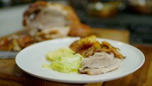 Slow roast shoulder of pork with roasties and apple sauce with hispi cabbage